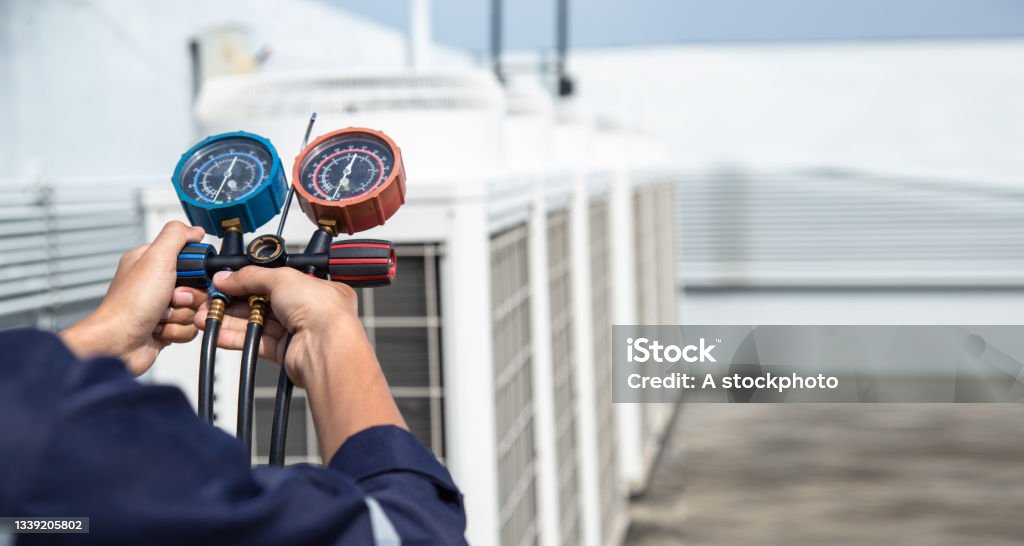 Technician is checking air conditioner ,measuring equipment for filling air conditioners . Technician is checking air conditioner ,measuring equipment for filling air conditioners , service and maintenance air conditioner . Air Conditioner Stock Photo