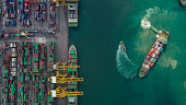 istock Container ship in export and import business and logistics. Shipping cargo to harbor by crane. Water transport International. Aerial view and top view. 1339206031
