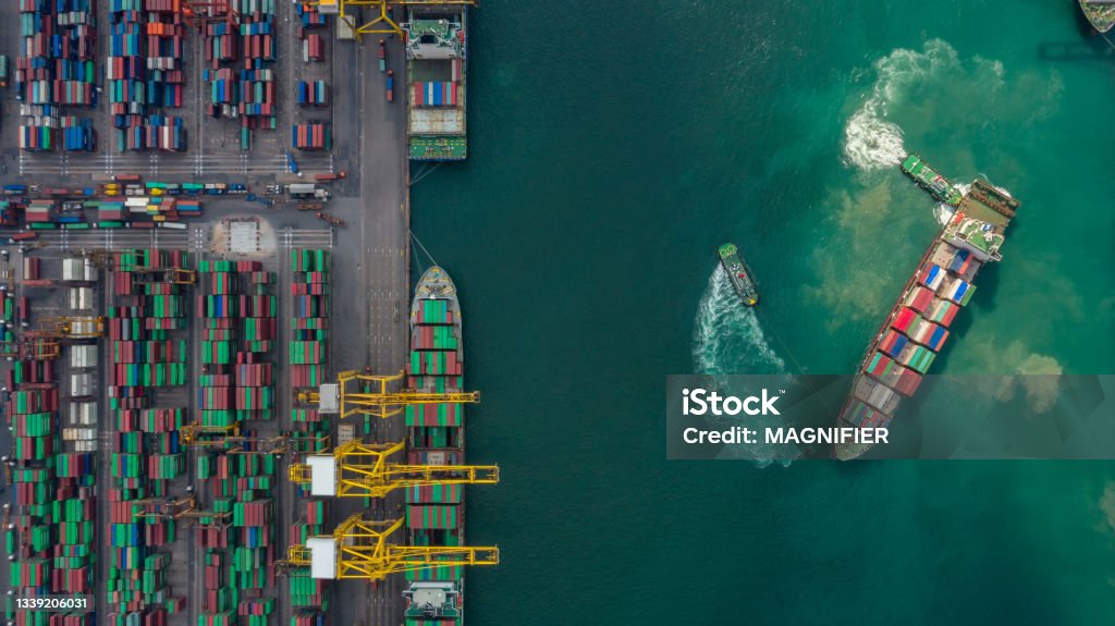 Container ship in export and import business and logistics. Shipping cargo to harbor by crane. Water transport International. Aerial view and top view. Commercial Dock Stock Photo