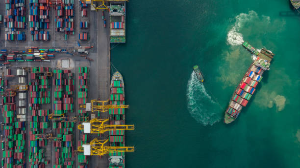 kontenerowiec w eksporcie i imporcie oraz logistyce. wysyłka ładunku do portu dźwigiem. transport wodny międzynarodowy. widok z lotu ptaka i widok z góry. - port ship zdjęcia i obrazy z banku zdjęć