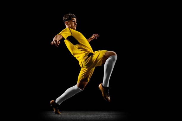 istock One profession young male football player training on black backround 1339206175