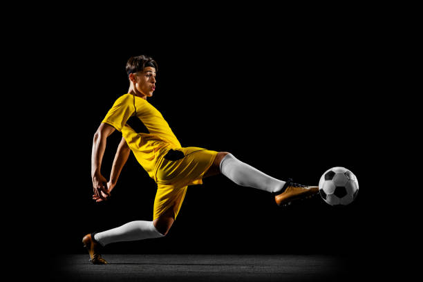 istock One profession young male football player training on black backround 1339206176