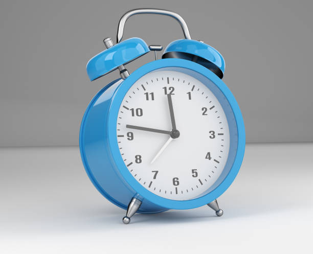 istock Blue Alarm clock on a white desk 1339206343