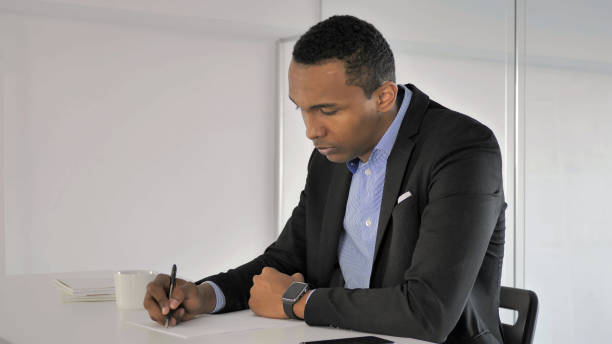 istock African Businessman Writing at Work, Paperwork 1339207123