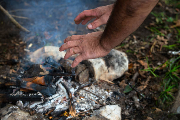 istock Man traveler warming his hands at a fire closeup. 1339209935