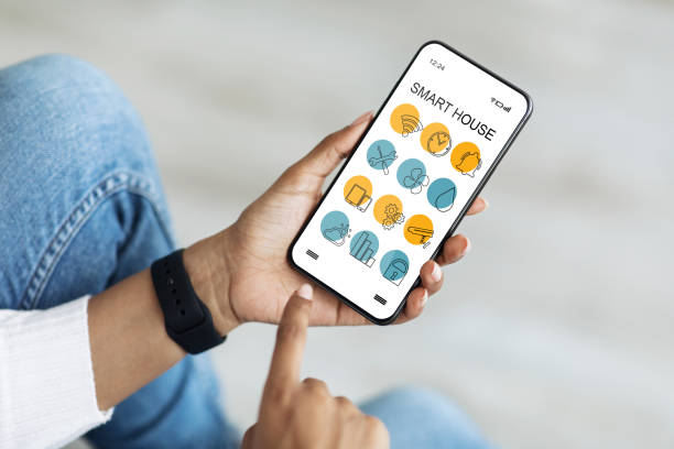istock Cellphone with smart home app in black lady hands, closeup 1339212099