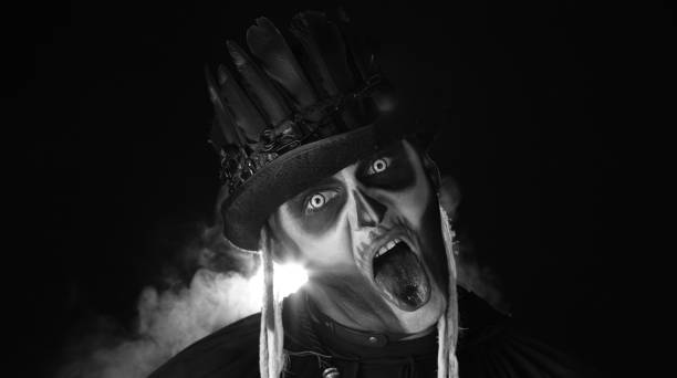 istock Sinister, crazy man with skeleton makeup. Guy making angry faces, shaking head, showing tongue 1339212110