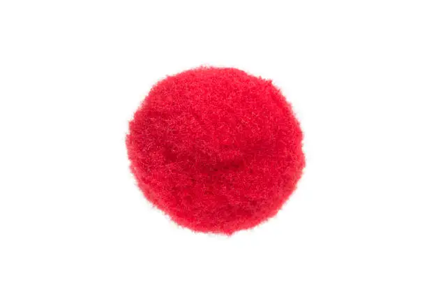 Red fluffy textile pompom on white background