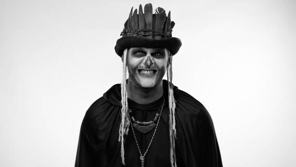 istock Sinister man with horrible Halloween skeleton makeup making faces, looking at camera trying to scare 1339212613