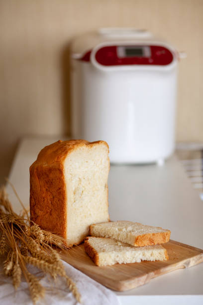 istock Sliced bread from a bread maker with wheat spikelets on a board with a kitchen napkin 1339212894