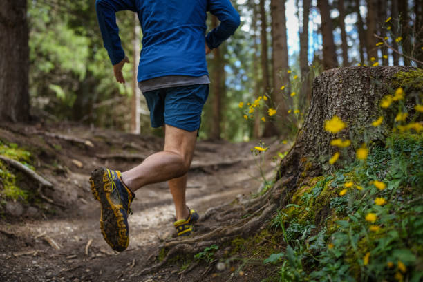 istock Man trail running in the forest, jumping on rough terrain 1339213273