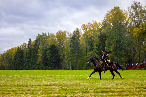 Borodino, Moscow Region, Russia - September 05, 2021: The lone Napoleonic war reenactor riding a horse at the battle of Borodino reenactment in Moscow region, Russia.