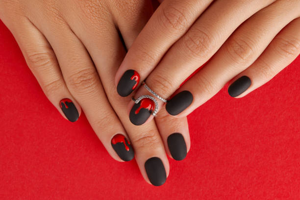 Manicured female hands with fashion accessories. Trendy autumn halloween bloody spooky nail design. Manicured female hands with fashion accessories on red background. Trendy autumn halloween bloody spooky nail design. fall nail art stock pictures, royalty-free photos & images