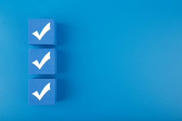 drei häkchen auf blauen würfeln vor blauem hintergrund mit kopierraum - checkliste stock-fotos und bilder