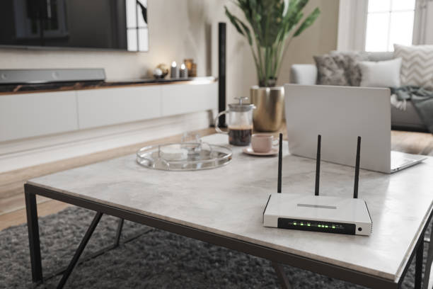 internet-router und laptop auf couchtisch im modernen wohnzimmer mit verschwommenem hintergrund - modem stock-fotos und bilder