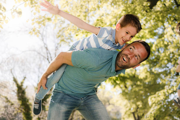 istock Playful father having fun while piggybacking his son in nature. 1339223641