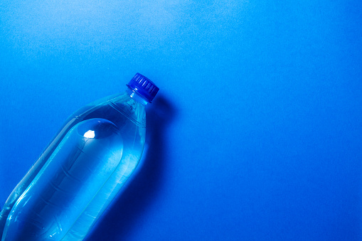 Bottle of still water on blue background
