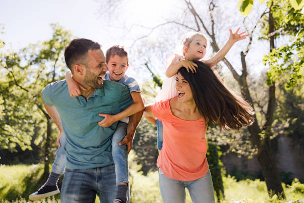istock Playful family having fun while piggybacking in springtime. 1339224197
