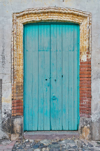 istock Light blue painted antique wooden door facade with copy space 1339224398