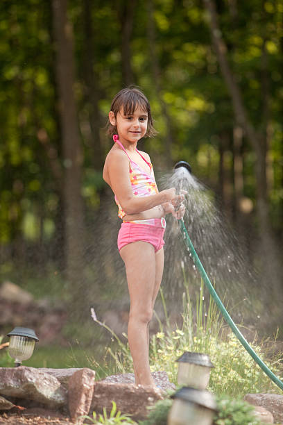 istock Girl waters the lawn from a hose 133922588