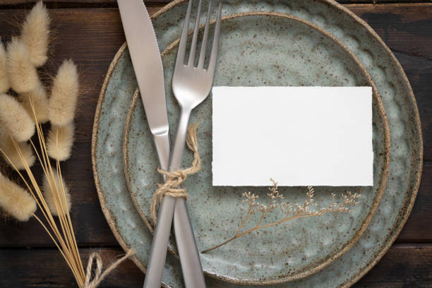istock Blank paper card on plate with fork and knife and dried plants 1339228170