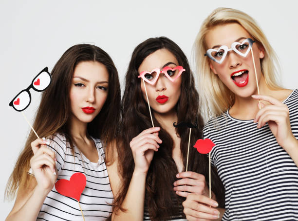 three young women holding paper party sticks - costume mustache child disguise imagens e fotografias de stock