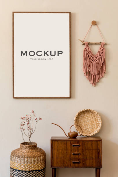 istock Modern scandinavian living room interior with mock up poster frame, design retro commode, macrame, rattan decoration and elegant personal accessories. Japandi. Template. Stylish home decor. Beige wall 1339234978