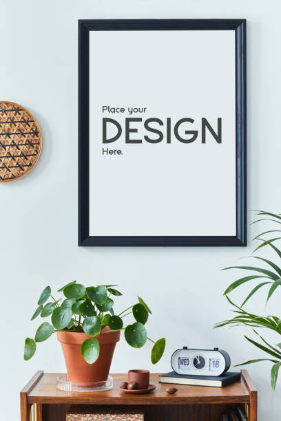 istock Stylish scandinavian living room interior with retro commode, black mock up poster frame, clock, plan, decoration, book and personal accessories in home decor. Template. 1339234979