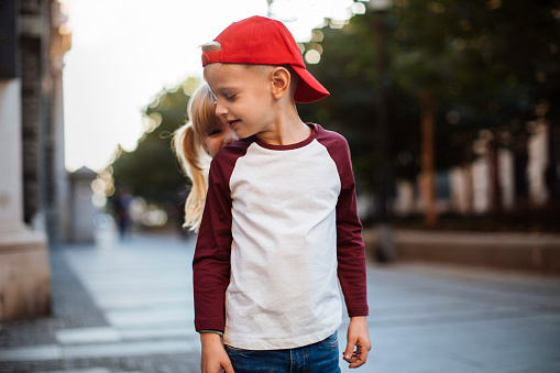 Portrait of a cute little boy with her sister hiding behind his back