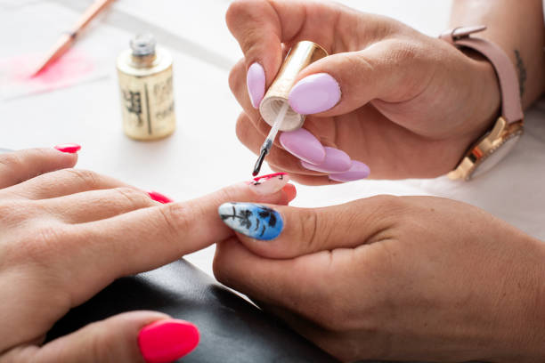 Manicure in a beauty salon Manicurist painting a woman's fingernails in a beauty center nail salon stock pictures, royalty-free photos & images