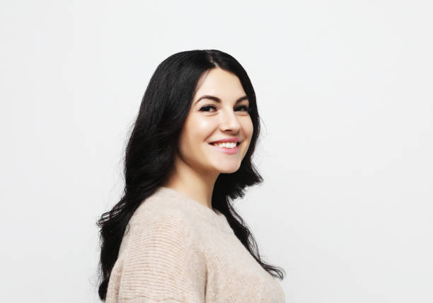 istock positive female with cheerful expression, dressed in casual clothes, over white background. Beautiful woman indoor 1339239405