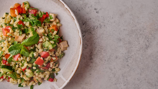 istock Panoramic view tabbouleh salad. Traditional Arabic dish with parsley, mint, bulgur, tomatoes 1339241393