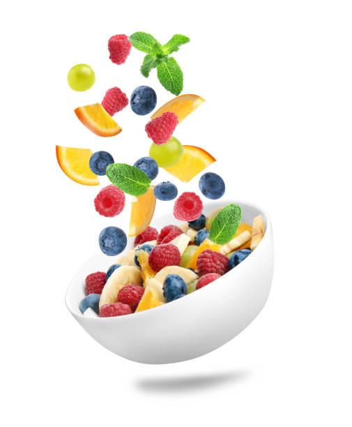istock Fresh ingredients for fruit salad falling into bowl on white background 1339241687