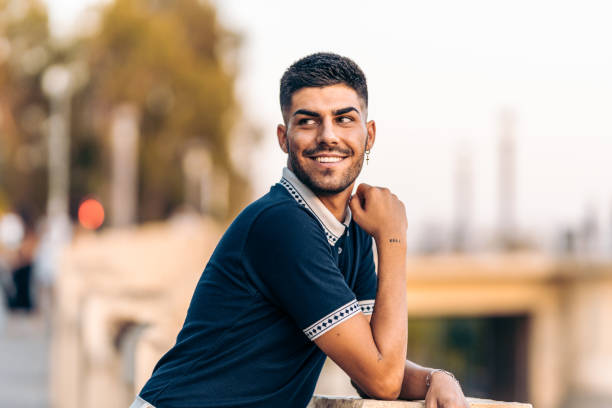 istock Man in modern clothes looking distracted while smiling in the street 1339242440
