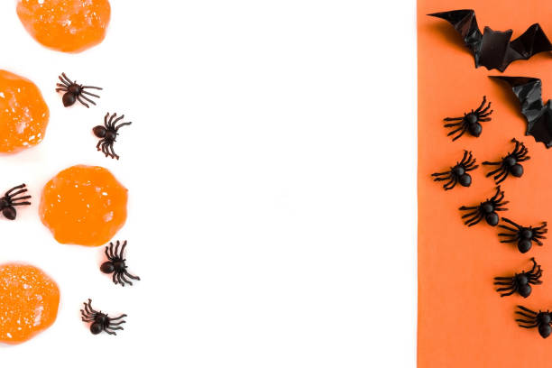 istock Halloween holiday. Flatly on a white and orange baackground. Bats and spiders. Copyspace 1339243507