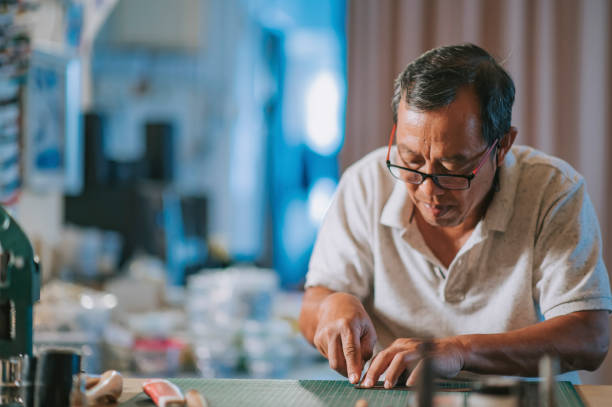 istock asian chinese senior man working in his studio on handmade leather watch strips 1339243728