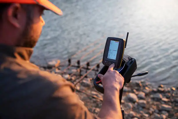 Photo of Carp Fishing, Controlling Sonar On Modern Electric Boat.