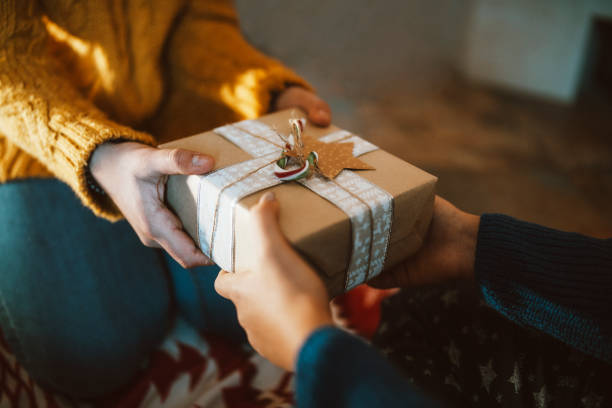 mains donnant un cadeau de noël en gros plan - hand wrap photos et images de collection