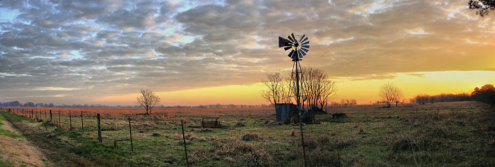 A panoramic sunrise view of a windmill near Hockley Texas
