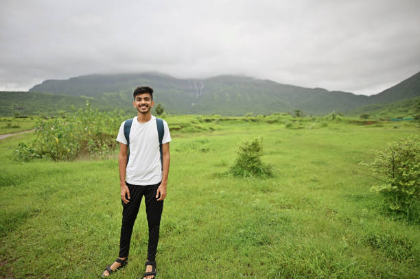 istock Young man standing in nature surrounded by green mountains 1339250441