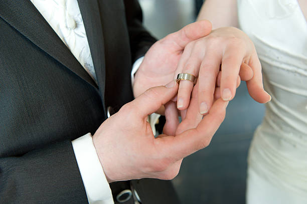 istock Groom Placing Wedding Ring on Bride's Finger 133925112