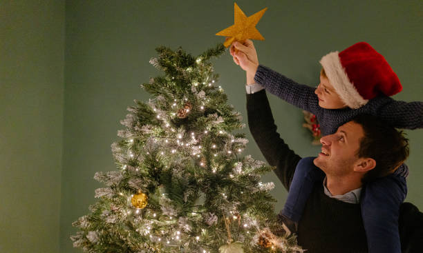istock Putting star on the top of a Christmas tree 1339251973