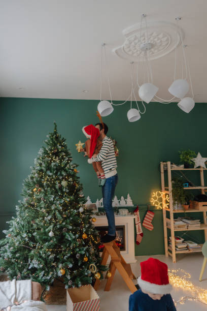 istock Single father's decorating Christmas tree with his boys 1339254550