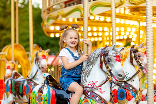 Happy little girl on a merry go round filled with joy