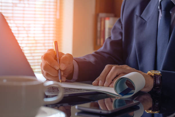 hombre de negocios escribiendo a mano y firmando cheque bancario blanco vacío - ceo fotografías e imágenes de stock