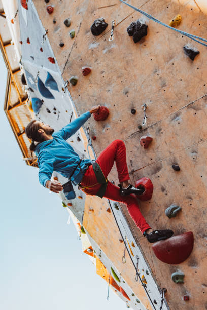 istock Daily workouts. Young man professional rock climber practicing at training center in sunny day, outdoors. Concept of healthy lifestyle, activity 1339262595