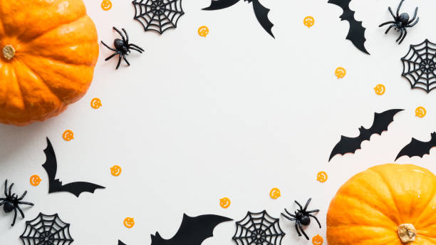 istock Happy Halloween holiday concept. Flat lay composition with pumpkins, bats, spiders, web on white desk. Minimal style. Halloween frame, banner design. 1339267047