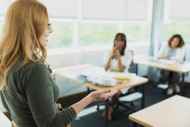 istock Focus on foreground as teacher lectures to adult students 1339268536