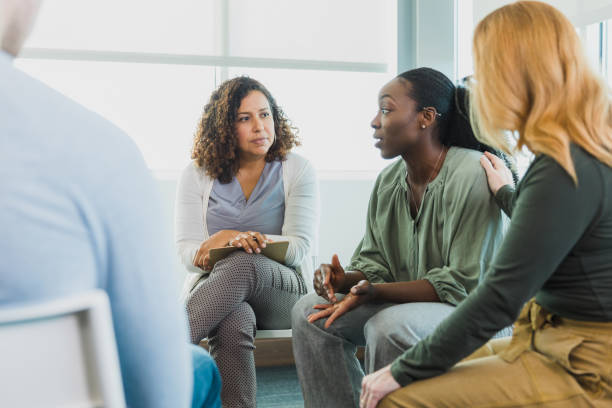 istock Woman sharing in group therapy comforted by friend 1339268581