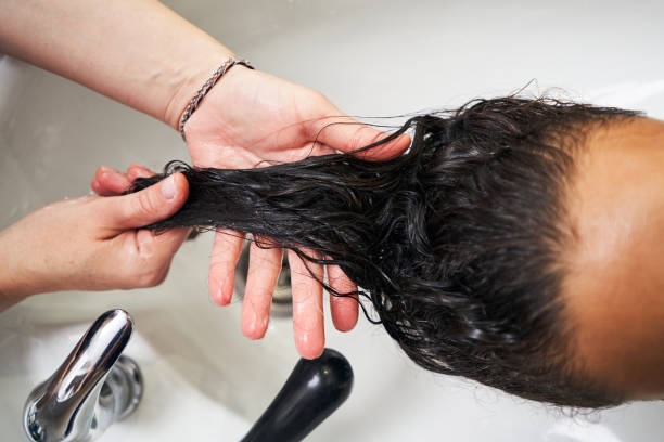 istock Hair stylist splashes protective mask during washing 1339268737